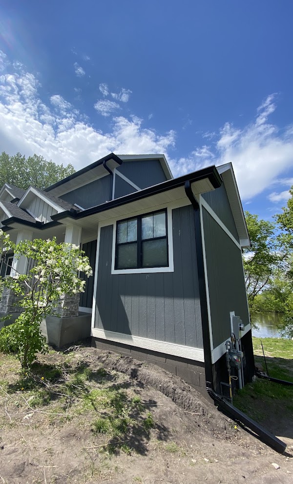 Black seamless gutters and downspouts on a lake home