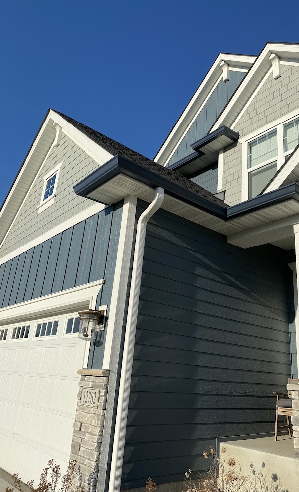 Seamless gutters with a white downspout on a two story home