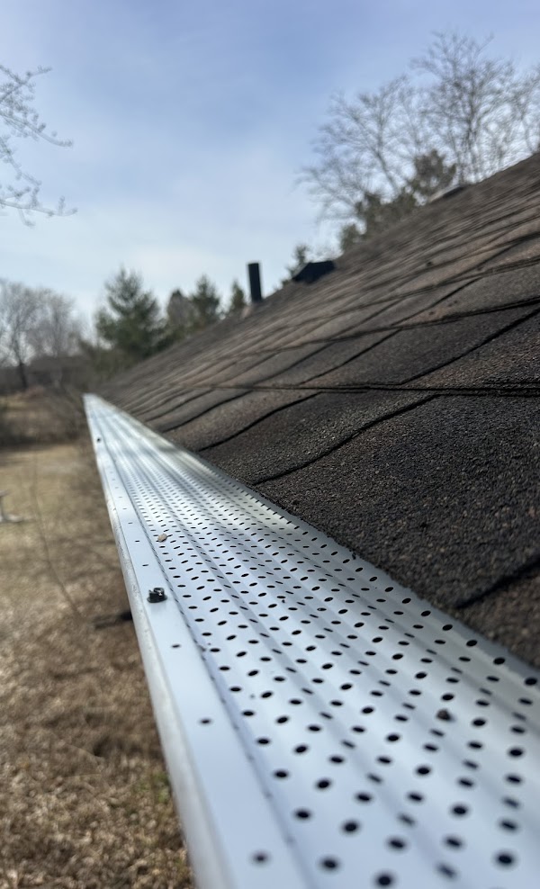 Gutter guards installed along a shingled roof in Minnesota
